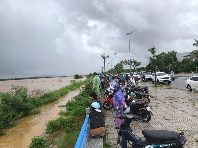 Nhiều người dân đang xem lực lượng chức năng giải cứu 8 người dân đang mắc kẹt giữa dòng nước lũ sông Trà Khúc.